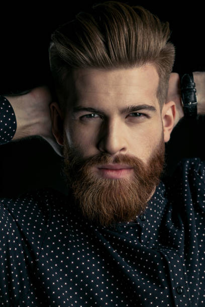 istock Handsome bearded man hipster with hands behind head looking at camera 658846266