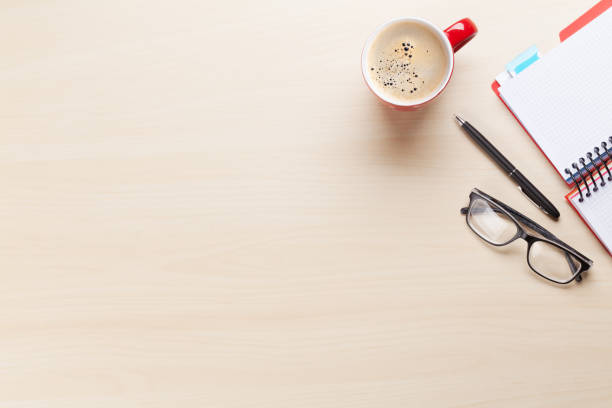 istock Office desk with coffee, notepad and glasses 658847258
