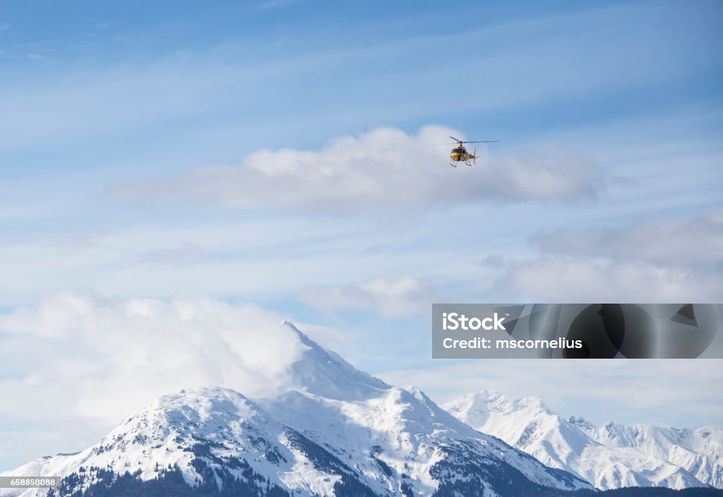 Helicopter over mountains Helicopter over mountain peaks near Haines Alaska transporting heliskiing clients to the mountains. Alaska - US State Stock Photo