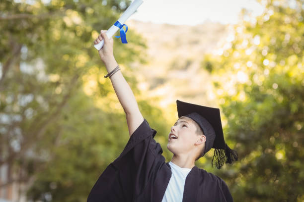 istock Excited graduate schoolboy with degree scroll in campus 658850184