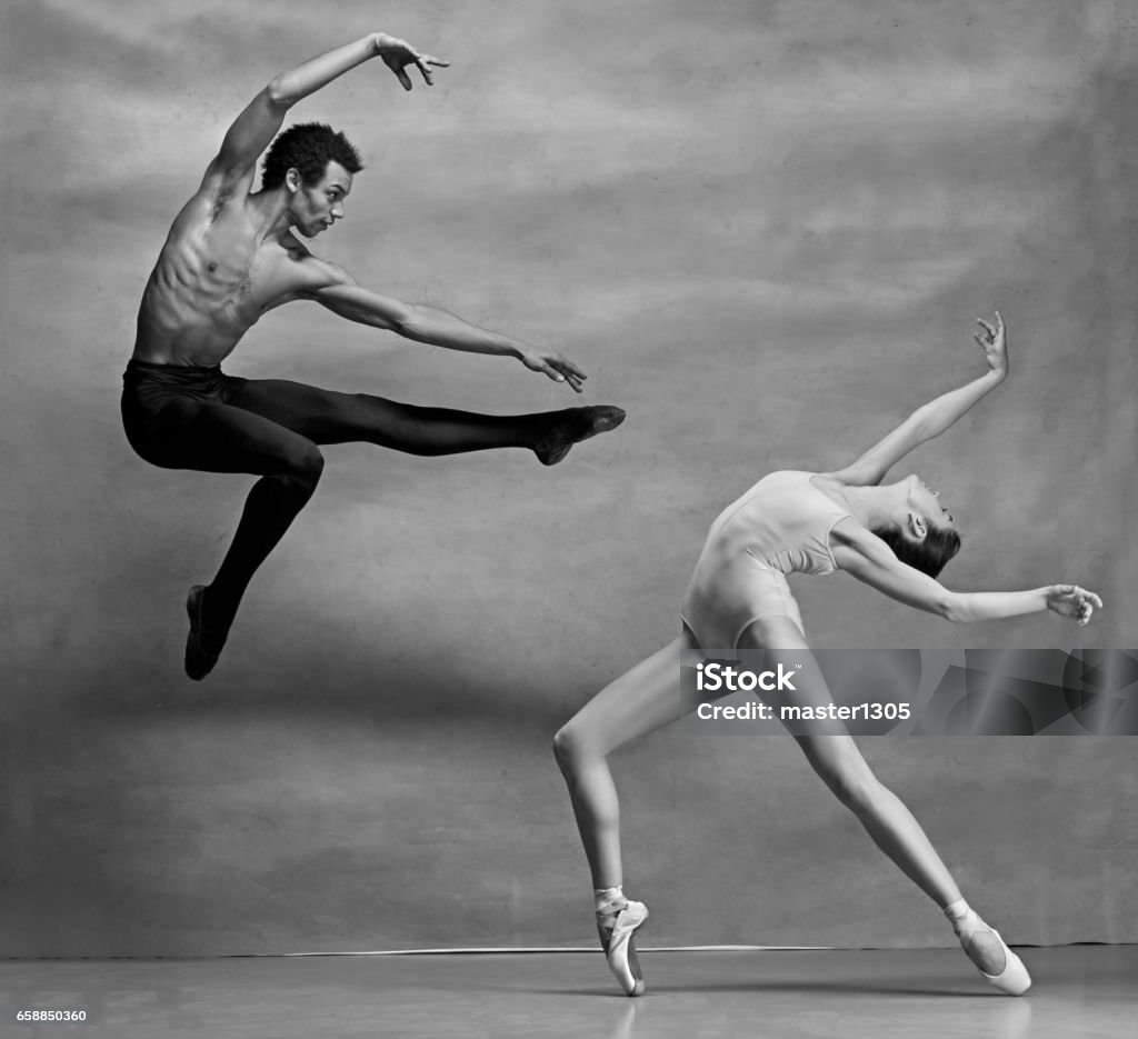 Couple de danseurs de ballet posant sur fond gris - Photo de Danse classique libre de droits
