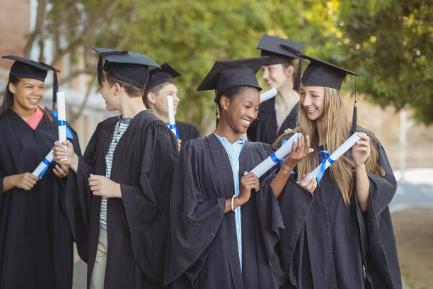istock Graduate school kids standing with degree scroll in campus at school 658850628