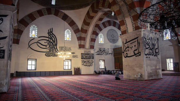 People are praying in Grand Mosque Turkish Ulu Cami. The mosque is most important mosque in Bursa and a landmark of early Ottoman architecture built in 1399 Bursa, Turkey - May 24, 2014: People are praying in Grand Mosque Turkish Ulu Cami. The mosque is most important mosque in Bursa and a landmark of early Ottoman architecture built in 1399 grand mosque stock pictures, royalty-free photos & images