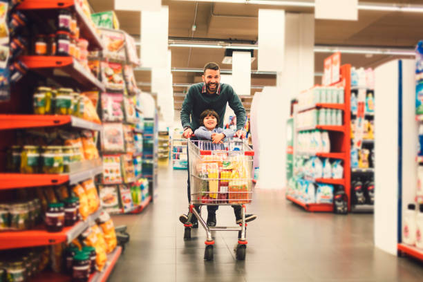 pai e filho em um supermercado. - carrinho de criança - fotografias e filmes do acervo