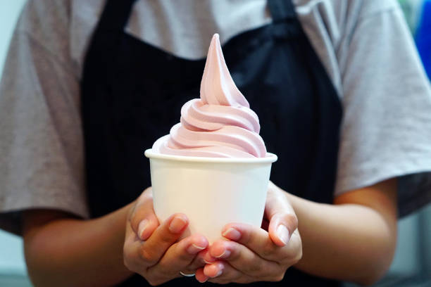 Closeup of woman 's hand holding takeaway cup with organic frozen yogurt ice cream, It's delicious and healthy enjoy eating concept. Closeup of woman 's hand holding takeaway cup with organic frozen yogurt ice cream, It's delicious and healthy enjoy eating concept. frozen yoghurt stock pictures, royalty-free photos & images