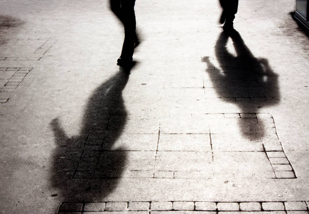 istock Shadow of a man on patterened sidewalk 658863276