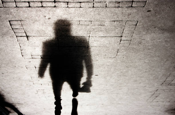 istock Shadow of a man on patterened sidewalk 658863494