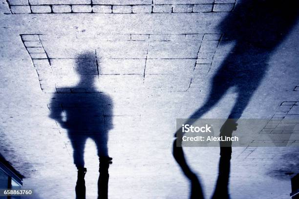 Shadow Of A Man On Patterened Sidewalk Stock Photo - Download Image Now - Sexual Assault, Women, Black And White