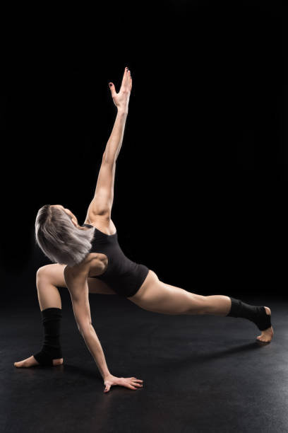 istock Young athletic woman contemporary dancer posing on black 658866996