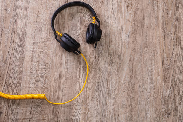 istock Headphones with yellow cable. Wooden background. 658867274