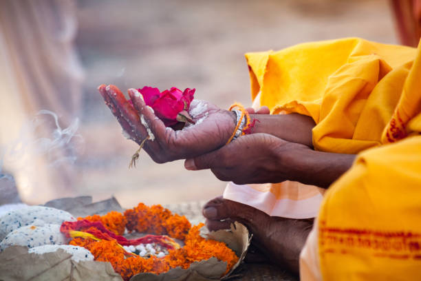 les fleurs sacrées sont prises pour le culte sur la main à la rivière ganges - cérémonie photos et images de collection