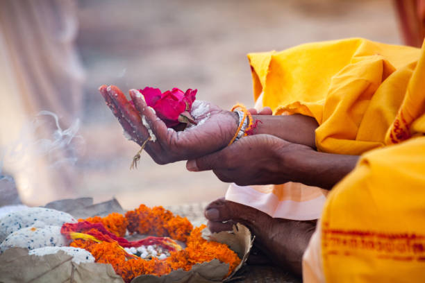 Sacred flowers are taken for worship on hand at river Ganges Varanasi, India - December 16, 2015 : Sacred flowers are taken for worship on hand at river Ganges, varanasi, uttar pradesh, india. varanasi stock pictures, royalty-free photos & images