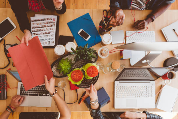 istock Creative people sharing food and file at table 658871814