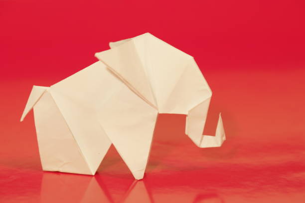 Paper elephant origami is isolated on the background. Elephant made of paper. Japanese culture. Symbol. Wild nature. Paper elephant origami is isolated on the background. Elephant made of paper. Japanese culture. Symbol. Wild nature. бумага stock pictures, royalty-free photos & images