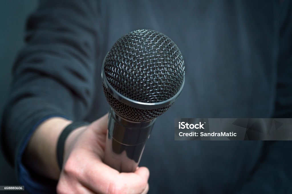 Journalist making speech with microphone and hand gesturing concept for interview. Journalist making speech with microphone and hand gesturing concept for interview. Selective focus. Adult Stock Photo