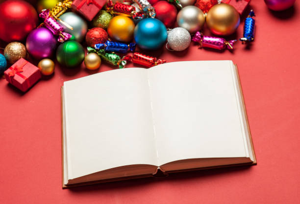 istock opened notebook and beautiful christmas decorations on the wonderful red background 658884484