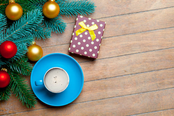 istock fir tree branches, cup of coffee, gift and colorful baubles on the wonderful brown wooden background 658884708