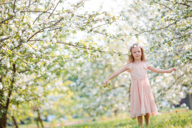 istock Little girl in blooming cherry tree garden outdoors on Easter eve 658890580