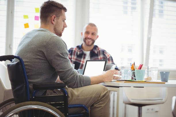 istock Handicap businessman sitting with colleague in office 658901822