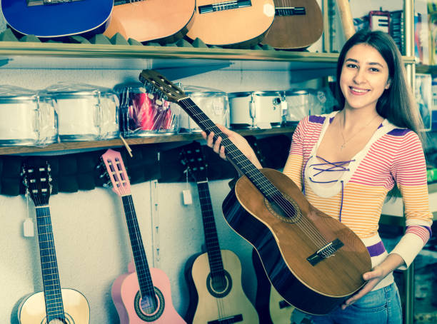 istock girl choosing acoustic guitar 658906014