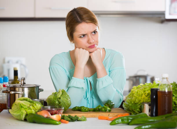 istock Young female with rotten vegetables at home 658909774