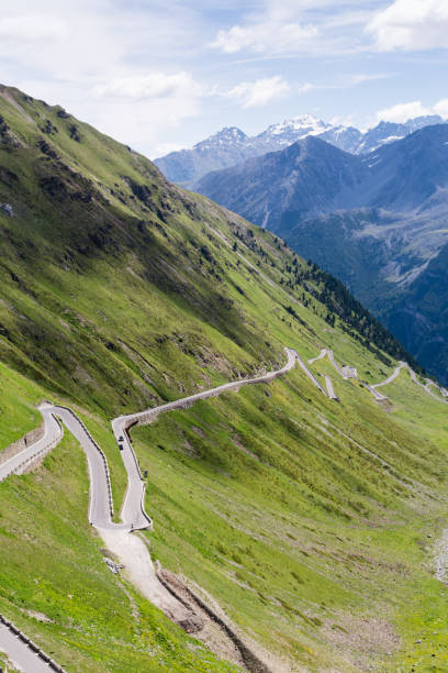 istock Alp road surrounded by blue alp high mountains on background. 658911230