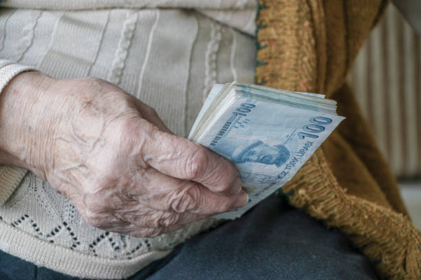 Wrinkled hand holding Turkish Lira banknotes stock photo