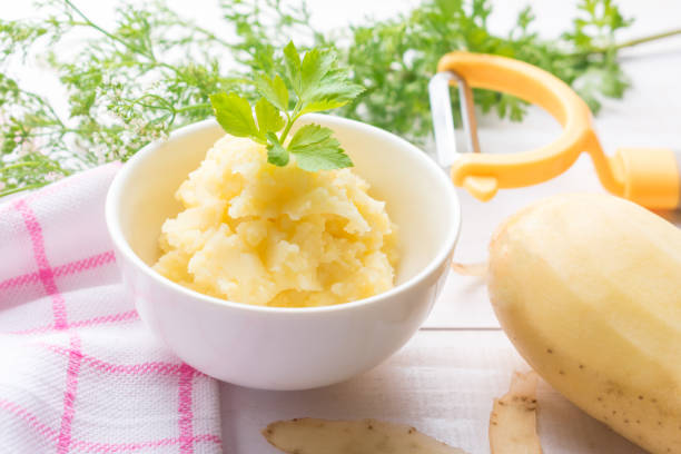 istock Mashed potato in a little bowl on white wooden background. 658927526