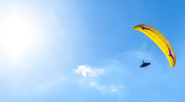 istock Paraglider flying against the blue sky with white clouds. 658938928