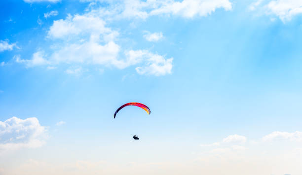 istock Paraglider flying against the blue sky with white clouds. 658939826