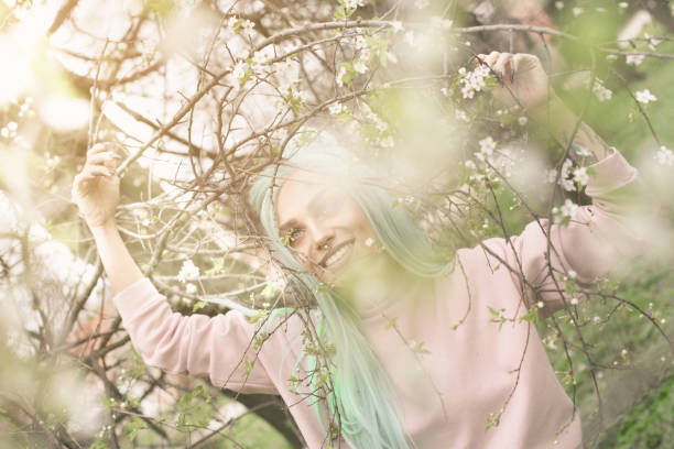 istock Mint haired young woman in cherry blossom. 658945304
