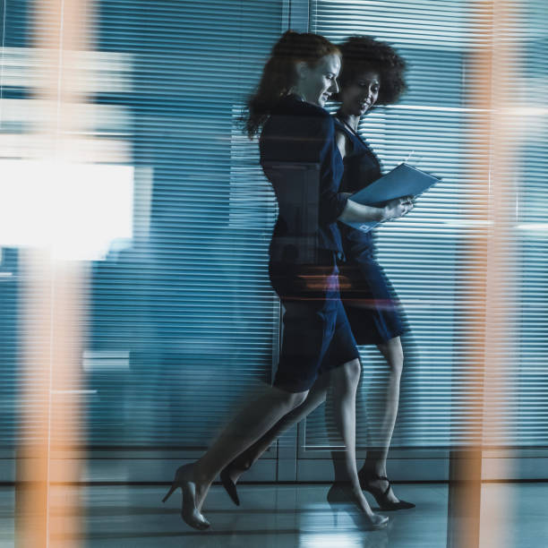 istock Two Businesswomen Walking Along The Corridor 658956014
