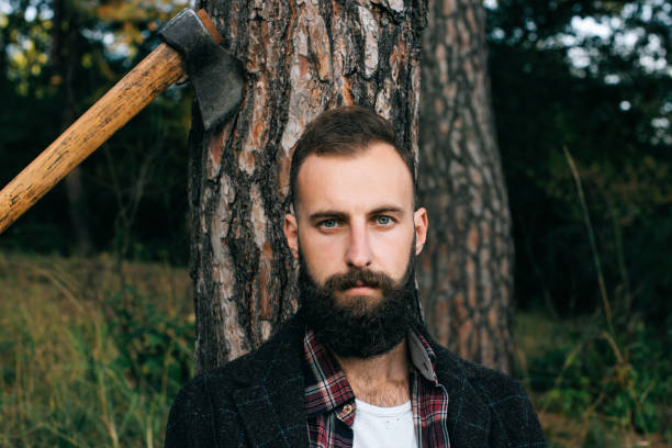 istock Portrait brutal bearded hipster man in the forest with ax 658961448