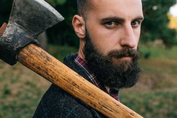 istock Portrait brutal bearded hipster man in the forest with ax 658963022