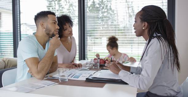 istock Insurance agent consulting couple in their home 658963654