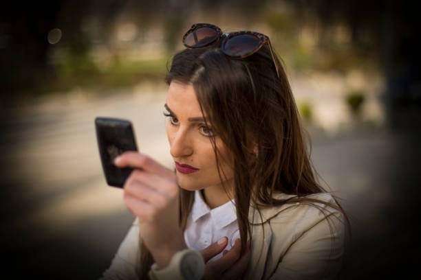istock Beautiful woman corrects make-up on the street 658973288