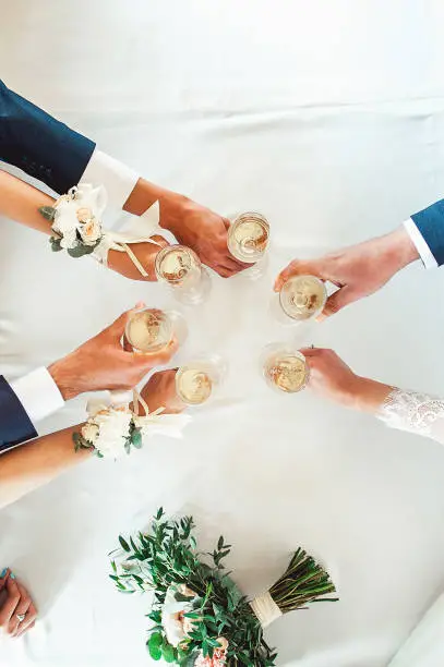 Photo of People hold in hands glasses with white wine. wedding party.