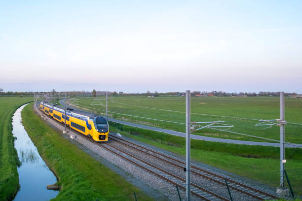 passagierstrein van de nederlandse spoorwegen (ns) rijden in een landelijke omgeving - trein nederland stockfoto's en -beelden