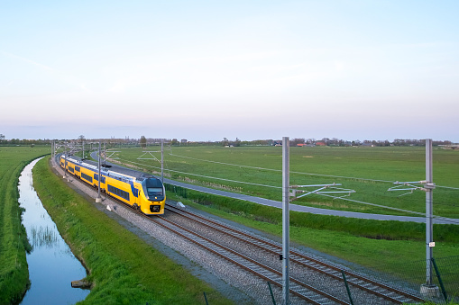 Passenger train of the Dutch Railways (NS) driving in a rural landscape