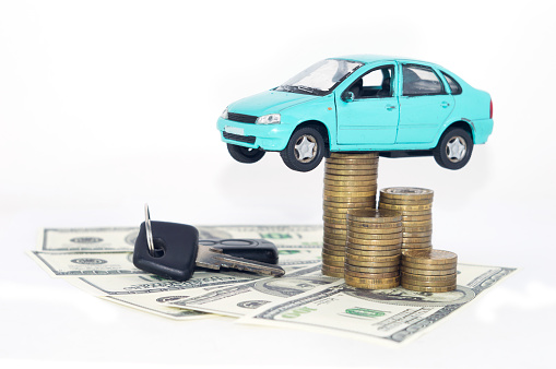A blue car with coins money black keys and dollars isolated on white background.