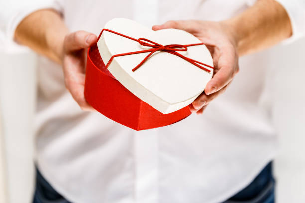 istock Male hands holding a heart-shaped gift box. 659018580