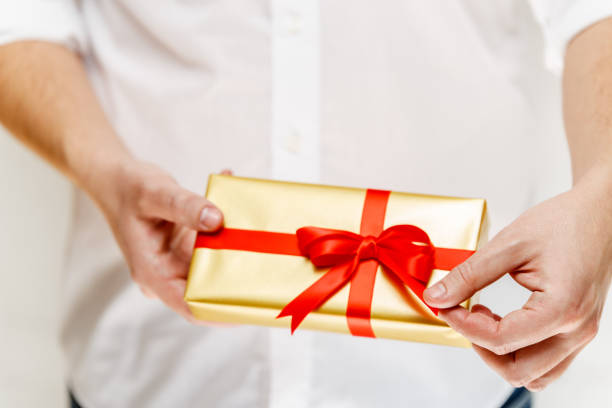 istock Male hands holding a gift box with ribbon. 659020144