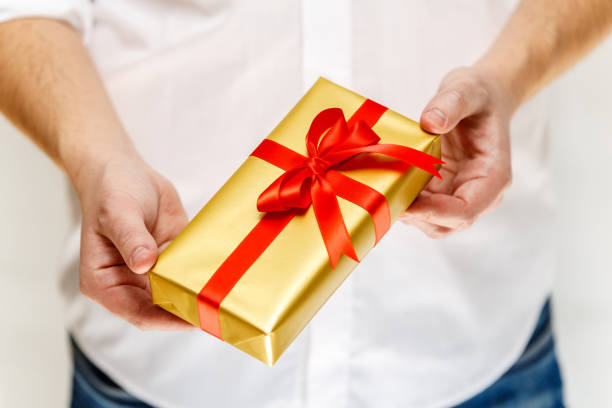 istock Male hands holding a gift box with ribbon. 659020272