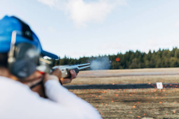 Aiming for perfection Professional trap shooter shooting clay targets. trap shooting stock pictures, royalty-free photos & images