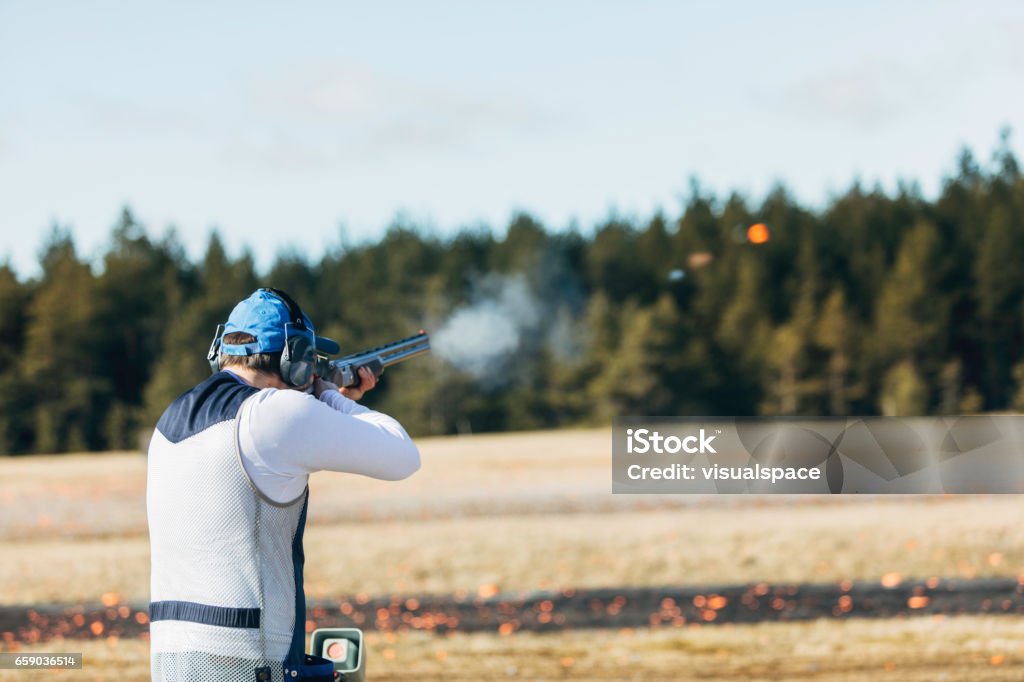 Clay target shooter Professional trap shooter shooting clay targets. Skeet Shooting Stock Photo