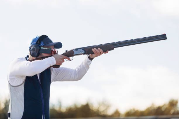 Clay target shooter Professional trap shooter shooting clay targets. trap shooting stock pictures, royalty-free photos & images