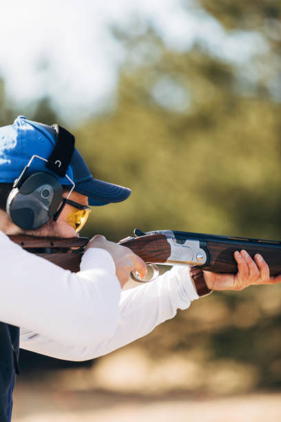 Clay target shooter Professional trap shooter shooting clay targets. trap shooting stock pictures, royalty-free photos & images