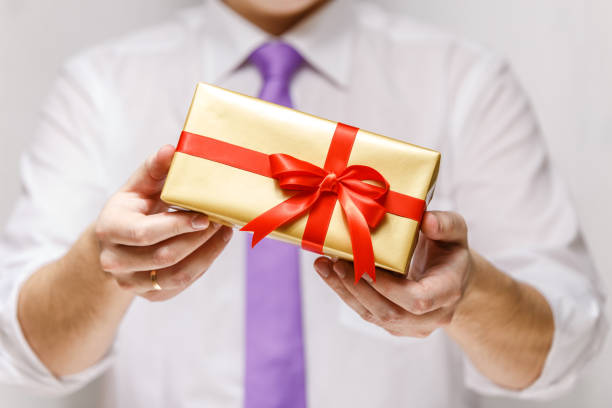 istock Male hands holding a gift box with ribbon. 659039248