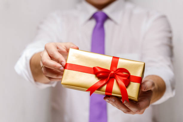 istock Male hands holding a gift box with ribbon. 659043196
