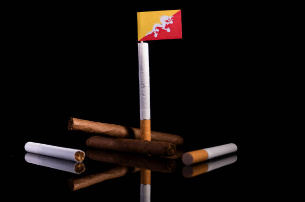 Bhutan flag with cigarettes and cigars. Tobacco Industry concept. stock photo